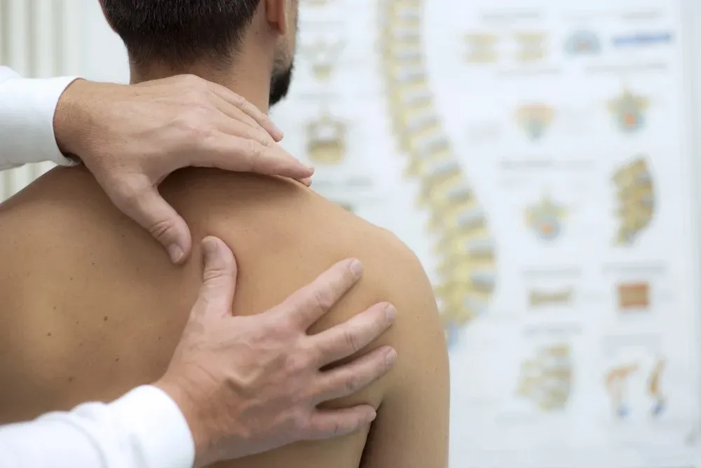 Fysioterapeut undersöker en patients skuldra